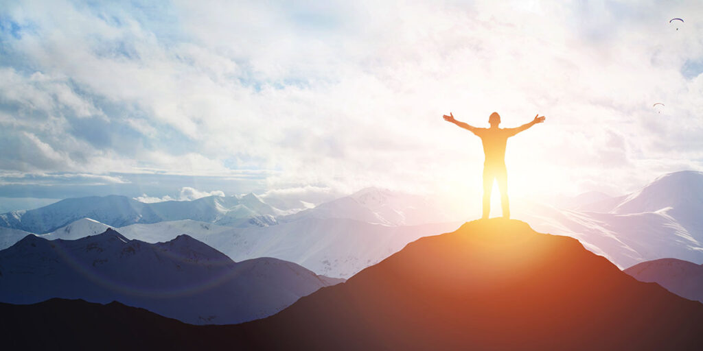 man standing on mountains watching sunrise